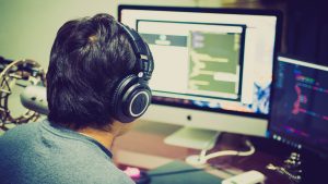 Man editing audio on a computer